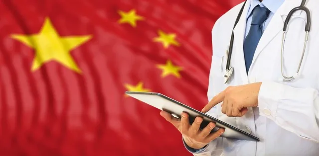 Médico consultando um tablet diante de uma bandeira chinesa